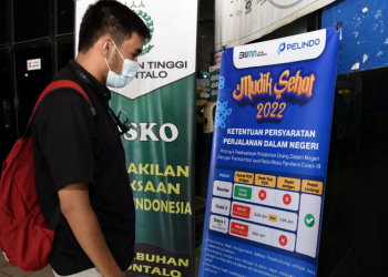 Seorang warga membaca syarat perjalanan dalam negeri yang dipajang di Posko Pelayanan Terpadu Angkutan Lebaran Pelindo Gorontalo, Selasa (19/4/2022). (Foto: Haris)