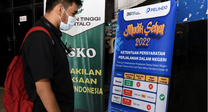 Seorang warga membaca syarat perjalanan dalam negeri yang dipajang di Posko Pelayanan Terpadu Angkutan Lebaran Pelindo Gorontalo, Selasa (19/4/2022). (Foto: Haris)