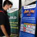 Seorang warga membaca syarat perjalanan dalam negeri yang dipajang di Posko Pelayanan Terpadu Angkutan Lebaran Pelindo Gorontalo, Selasa (19/4/2022). (Foto: Haris)