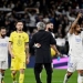 Pemain depan Real Madrid Prancis Karim Benzema (tengah) dan pelatih Real Madrid Italia Carlo Ancelotti berpelukan di akhir pertandingan sepak bola leg kedua perempat final Liga Champions UEFA antara Real Madrid CF dan Chelsea FC di stadion Santiago Bernabeu di Madrid pada 12 April 2022. (Suara.com)