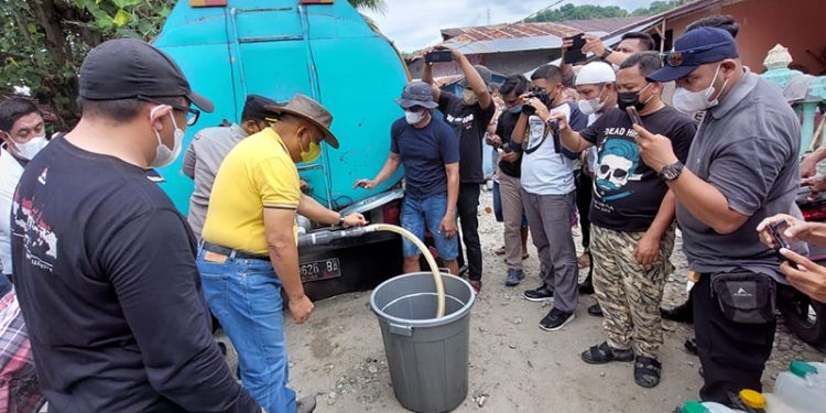 Gubernur Rusli Habibie didampingi perwakilan Pemerintah Kabupaten Bone Bolango dan unsur Kepolisian saat menyalurkan minyak goreng kepada masyarakat yang ada di Kecamatan Kabila Bone. (Foto Istimewa)