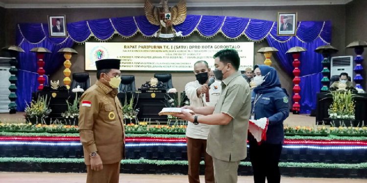 Foto : Ketua DPRD Kota Gorontalo Hardi Sidiki ketika menerima dokumen atas 3 ranperda usul inisiatif eksekutif, yang diserahkan oleh walikota Gorontalo, Marten Taha.(foto: Sari/Gopos)