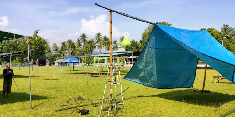 Sejumlah persiapan dilakukan masyarakat mulai dari pendirian tenda dan lapak-lapak penjualan di Lapangan Porbat, Desa Payunga, Kecamatan Batudaa, Kabupaten Gorontalo, Jumat (15/4/2022). (Foto: Putra/Gopos)
