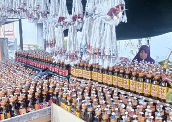 Salah satu penjual lampu botol di Jl. Sam Ratulangi menantikan pembeli. Sepekan menjelang tumbilotohe, pembeli lampu botol cenderung masih sepi. (farun/gopos)