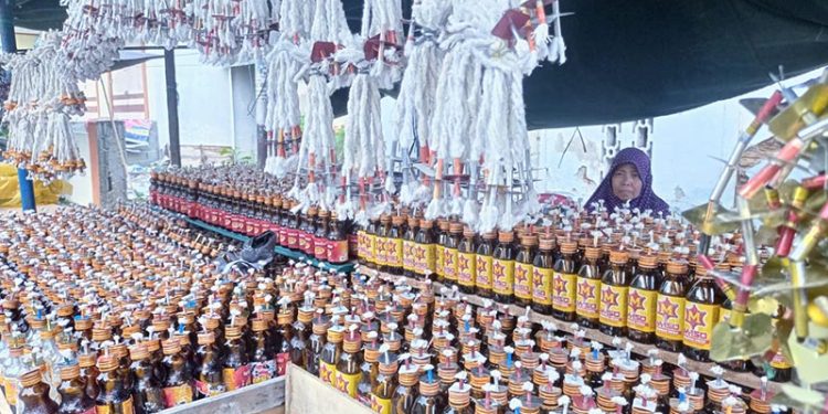 Salah satu penjual lampu botol di Jl. Sam Ratulangi menantikan pembeli. Sepekan menjelang tumbilotohe, pembeli lampu botol cenderung masih sepi. (farun/gopos)