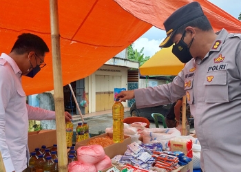 Kapolres Gorontalo Kota, AKBP Suka Irawanto didampingi Kasat Reskrim,  Iptu Mohamad Nauval Seno sedang memastikan ketersediaan minyak goreng di beberapa pasar tradisional di wilayah Kota Gorontalo. Jumat (8/4/2022). Foto : Humas