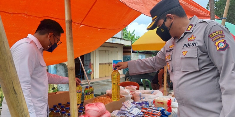 Kapolres Gorontalo Kota, AKBP Suka Irawanto didampingi Kasat Reskrim,  Iptu Mohamad Nauval Seno sedang memastikan ketersediaan minyak goreng di beberapa pasar tradisional di wilayah Kota Gorontalo. Jumat (8/4/2022). Foto : Humas