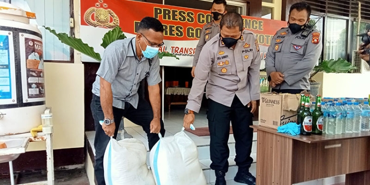 Kapolres Gorontalo Kota, AKBP Suka Irawanto sedang memperlihatkan miras hasil sitaan, Jum'at (1/4/2022). Foto : Sari/gopos