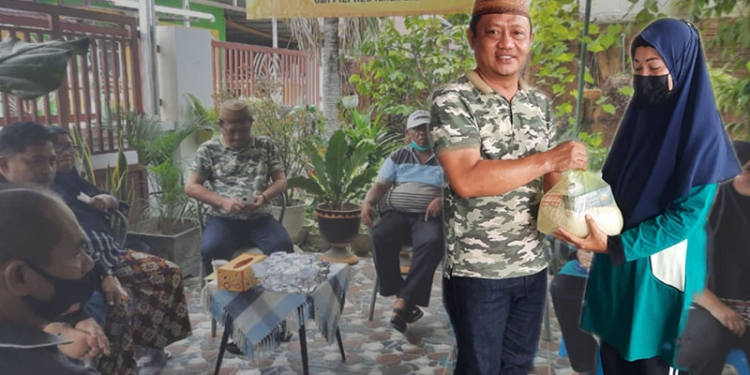 Anggota DPRD Kota Gorontalo, Irwan Hunawa ketika menyalurkan paket sembako kepada masyarakat.