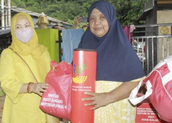 Ketua TP. PKK Provinsi Gorontalo Idah Syahidah saat menyerahkan bantuan kepada salah satu korban kebakaran rumah yang terjadi di pesisir muara di Jl Yos Sudarso Kelurahan Tenda, Kecamatan Hulonthalangi, Rabu (27/4/2022). (Foto: Rival)