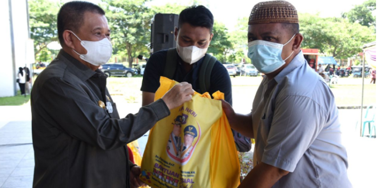 Wagub Gorontalo H. Idris Rahim (kiri), menyerahkan BLP3G kepada KPM di Kecamatan Kota Timur, Kota Gorontalo, Senin (25/4/2022). (Foto: Haris)