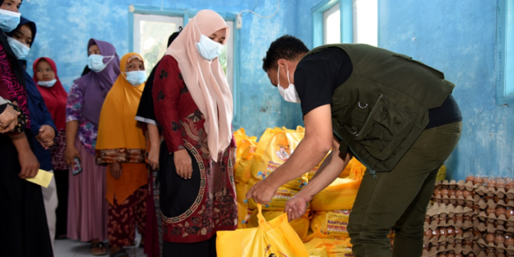 Seorang petugas (kanan) melayani penyaluran BLP3G untuk keluarga penerima manfaat di Kecamatan Bone Pantai, Kabupaten Bone Bolango, Jumat (8/4/2022). (Foto: Haris)