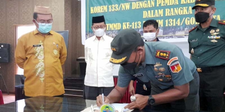 Lekol Kav Embi Triono saat menandatangani MoU dengan pemerintah daerah, terkait pekerjaan TMMD di wilayah Kecamatan Kwandang. (foto.isno)