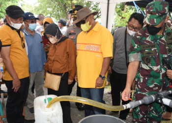 Gubernur Gorontalo Rusli Habibie (kemeja kuning) bersama istri dan Danrem 133/NWB Brigjen TNI Amrin Ibrahim saat mendistribusikan minyak goreng curah di Kantor Camat Kabila, Kabupaten Bone Bolango, Sabtu (16/4/2022). (Foto: Salman)