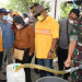 Gubernur Gorontalo Rusli Habibie (kemeja kuning) bersama istri dan Danrem 133/NWB Brigjen TNI Amrin Ibrahim saat mendistribusikan minyak goreng curah di Kantor Camat Kabila, Kabupaten Bone Bolango, Sabtu (16/4/2022). (Foto: Salman)