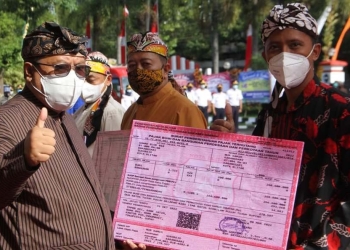 Wali Kota Blitar saat memberikan struk pelunasan pajak kepada salah satu peserta yang mengikuti Penetapan Pajak Bumi dan Bangunan Perdesaan dan Perkotaan (PBB-P2) Tahun 2022 dan Pekan Panutan Pajak di Kota Blitar, Senin (4/4/2022) di halaman Kantor Wali Kota Blitar. (Foto: Thoha/gopos)