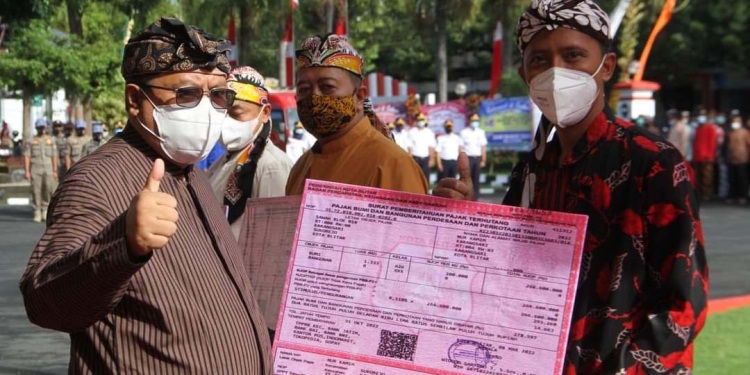 Wali Kota Blitar saat memberikan struk pelunasan pajak kepada salah satu peserta yang mengikuti Penetapan Pajak Bumi dan Bangunan Perdesaan dan Perkotaan (PBB-P2) Tahun 2022 dan Pekan Panutan Pajak di Kota Blitar, Senin (4/4/2022) di halaman Kantor Wali Kota Blitar. (Foto: Thoha/gopos)
