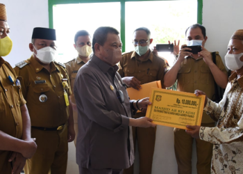Wagub Gorontalo H. Idris Rahim (tengah), menyerahkan secara simbolis bantuan dana hibah kepada pengurus masjid pada safari Ramadan di Kecamatan Marisa, Kabupaten Pohuwato, Selasa (12/4/2022). (Foto: Haris)