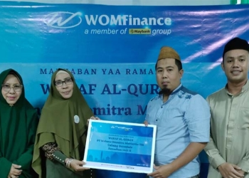 Kepala Cabang WOM Finance, Iswahyuddin Ilham  saat menyerahkan bantuan Al-Qur'an secara simbolis kepada Pembina Yayasan Ulumul Qur’an Gorontalo, Dr.Hj Saida Gani. (foto.istimewa)