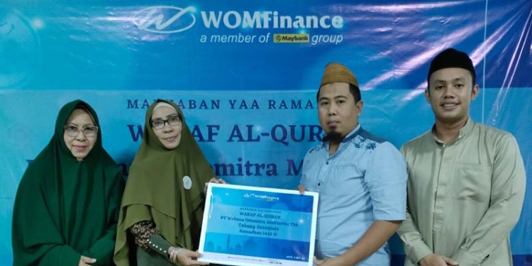 Kepala Cabang WOM Finance, Iswahyuddin Ilham  saat menyerahkan bantuan Al-Qur'an secara simbolis kepada Pembina Yayasan Ulumul Qur’an Gorontalo, Dr.Hj Saida Gani. (foto.istimewa)