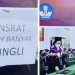 Prosesi wisuda Universitas Sam Ratulangi, Manado, Sulawesi Utara menjadi viral di media sosial karena seorang wisudawan memberikan secarik kertas berisi pesan dugaan pungli kepada sang rektor. (suara.com)