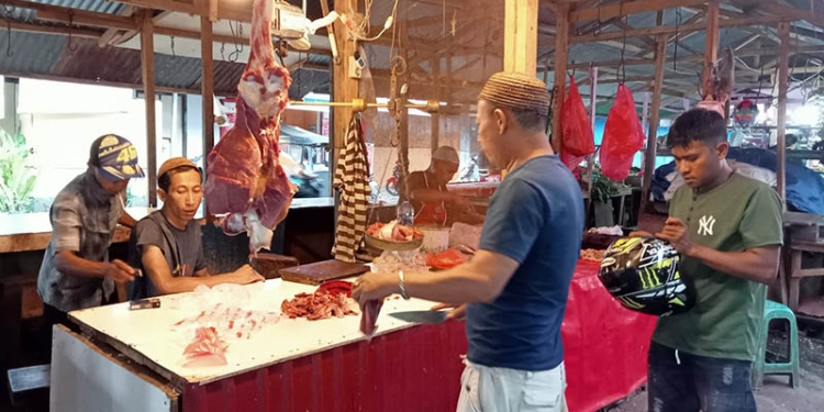 Penjual daging sapi di Pasar Sentral Kota Gorontalo sedang melayani konsumen. Permintaan yang tinggi dan pasokan yang kurang membuat harga daging sapi di Gorontalo masih tinggi H+3 lebaran Idulfitri. (sari/gopos)