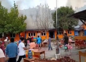 Para warga berusaha menyelamatkan sejumlah perabot dan barang-barang dari dalam kelas saat kebakaran yang melanda SDN 7 Bulango Utara, Selasa (3/5/2022). (istimewa)