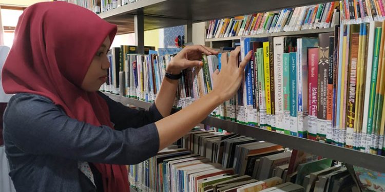 Salah seorang pengunjung sedang memilih buku di Perpustakaan Daerah Provinsi Gorontalo. (foto: Infopublik.id)
