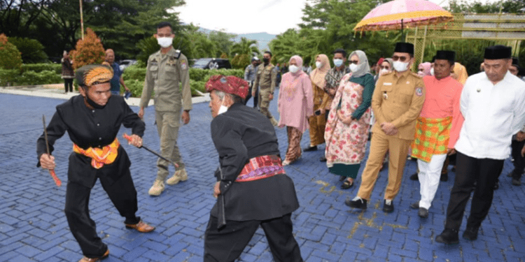 Penjabat Gubernur Gorontalo, Hamka Hendra Noer didampingi istri, saat diterima dengan adat Mopotilolo oleh Pemangku Adat Bone Bolango, pada kunker perdana Hamka bertempat di Rumah Jabatan Bupati Bone Bolango, Selasa (24/5/2022). (Foto: Salman)