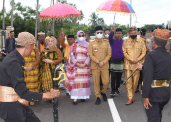 Penjagub Gorontalo, Hamka Hendra Noer bersama istri (tengah) disambut dengan upacara adat Mopotilolo di rumah jabatan Bupati Pohuwato, Senin (23/5/2022). (Foto: Salman)