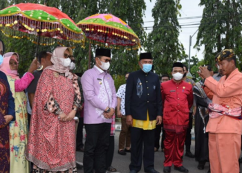 Penjabat Gubernur Gorontalo Hamka Hendra Noer bersama istri Istri drg. Gamaria Purnamawati Monoarfa saat disambut oleh Bupati Boalemo Anas Yusuf dan jajaran Pemda Boalemo dengan adat Mopotilolo, pada kunker perdana Hamka di Boalemo, Kamis (18/5/2022). (Foto: Salman)