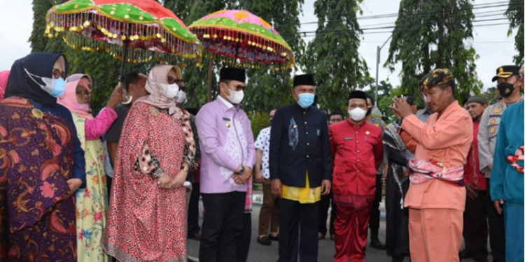 Penjabat Gubernur Gorontalo Hamka Hendra Noer bersama istri Istri drg. Gamaria Purnamawati Monoarfa saat disambut oleh Bupati Boalemo Anas Yusuf dan jajaran Pemda Boalemo dengan adat Mopotilolo, pada kunker perdana Hamka di Boalemo, Kamis (18/5/2022). (Foto: Salman)