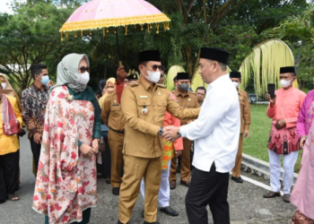 Penjagub Gorontalo, Hamka Hendra Noer didampingi istri, disambut Bupati Bone Bolango Hamim Pou saat kunjungan kerja pertamanya di Kabupaten Bone Bolango. Penyambutan ini juga dirangkaikan dengan adat Mopotilolo. (Foto: Salman)