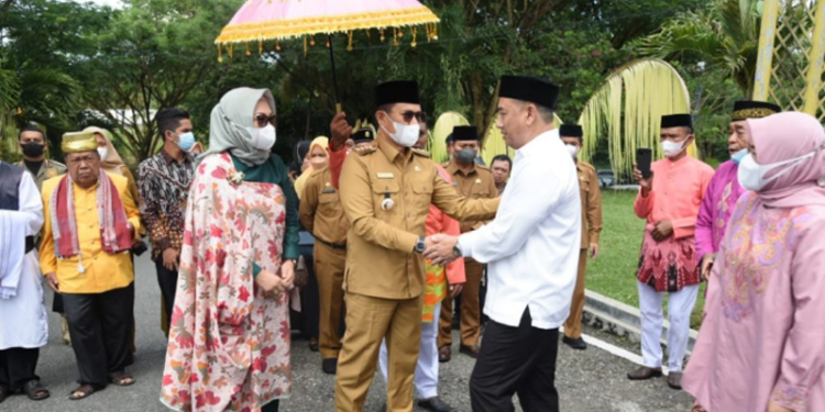 Penjagub Gorontalo, Hamka Hendra Noer didampingi istri, disambut Bupati Bone Bolango Hamim Pou saat kunjungan kerja pertamanya di Kabupaten Bone Bolango. Penyambutan ini juga dirangkaikan dengan adat Mopotilolo. (Foto: Salman)