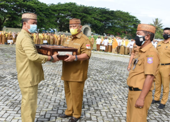 Gubernur Gorontalo Rusli Habibie menyerahkan pakaian dinasnya bersama Wakil Gubernur Idris Rahim untuk dimuseumkan Pemerintah Provinsi Gorontalo pada Apel Perdana Pegawai Usai Libur Lebaran, Senin (9/5/2022). (Foto: Salman)