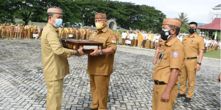 Gubernur Gorontalo Rusli Habibie menyerahkan pakaian dinasnya bersama Wakil Gubernur Idris Rahim untuk dimuseumkan Pemerintah Provinsi Gorontalo pada Apel Perdana Pegawai Usai Libur Lebaran, Senin (9/5/2022). (Foto: Salman)