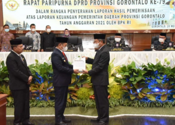 Penjabat Gubernur Gorontalo Hamka Hendra Noer saat menerima Penghargaan Opini Wajar Tanpa Pengecualian (WTP) dari BPK RI yang diserahkan oleh Auditor Utama Keuangan Negara VI DR. Dori Santosa atas Hasil Pemeriksaan Laporan keuangan Pemerintah Provinsi Gorontalo Tahun Anggaran 2021. WTP tahun ini menjadi yang ke 10 kalinya berhasil diraih Pemprov Gorontalo. (Foto: Salman)