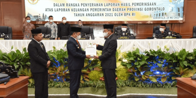 Penjabat Gubernur Gorontalo Hamka Hendra Noer saat menerima Penghargaan Opini Wajar Tanpa Pengecualian (WTP) dari BPK RI yang diserahkan oleh Auditor Utama Keuangan Negara VI DR. Dori Santosa atas Hasil Pemeriksaan Laporan keuangan Pemerintah Provinsi Gorontalo Tahun Anggaran 2021. WTP tahun ini menjadi yang ke 10 kalinya berhasil diraih Pemprov Gorontalo. (Foto: Salman)