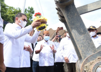 Pemecahan kendi di alat berat ekskavator oleh Pj Gubernur Gorontalo Hamka Hendra Noer saat mencanangkan pekerjaan kanal banjir Tanggidaa di Kecamatan Kota Timur, Kota Gorontalo, Rabu (18/5/2022). (Foto: Salman)