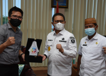 Penjabat Gubernur Gorontalo, Hamka Hendra Noer menerima cendera mata dari Kepala BPJS Ketenagakerjaan Cabang Gorontalo, Hendra Elvian di ruang kerjanya, Rabu (25/5/2022). (Foto: Salman)