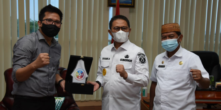 Penjabat Gubernur Gorontalo, Hamka Hendra Noer menerima cendera mata dari Kepala BPJS Ketenagakerjaan Cabang Gorontalo, Hendra Elvian di ruang kerjanya, Rabu (25/5/2022). (Foto: Salman)