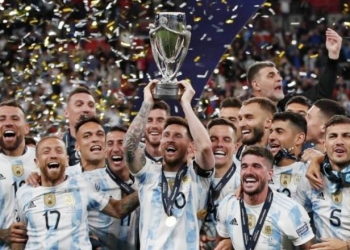Kapten timnas Argentina Lionel Messi (tengah) mengangkat piala Conembol-UEFA Cup of Champions setelah mengalahkan Italia dengan skor 3-0 padaFinallisima di Stadion Wembley, London, Kamis (2/6/2022) dini hari WIB. [AFP/Suara.com]