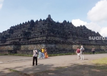 Wisatawan menikmati pemandangan di pelataran Candi Borobudur. Nantinya, hanya pemilik tiket khusus yang boleh berwisata hingga puncak candi. [Suara.com]