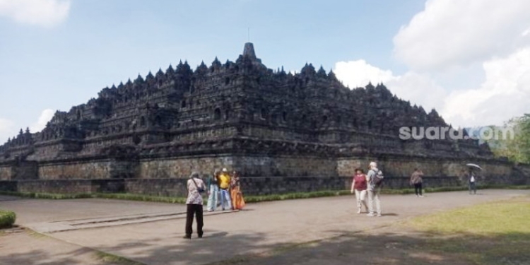 Wisatawan menikmati pemandangan di pelataran Candi Borobudur. Nantinya, hanya pemilik tiket khusus yang boleh berwisata hingga puncak candi. [Suara.com]