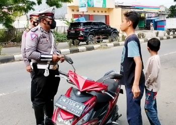 Pengendara yang tidak menggunakan helm SNI saat berkendara. (Foto: Putra/Gopos)