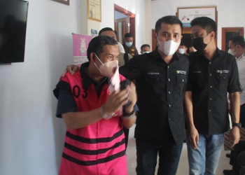 Kepala Dinas PUPR Pohuwato, AS, berjalan keluar dari ruang pemeriksaan Kejaksaan Tinggi Gorontalo, Jumat (17/6/2022). (istimewa)