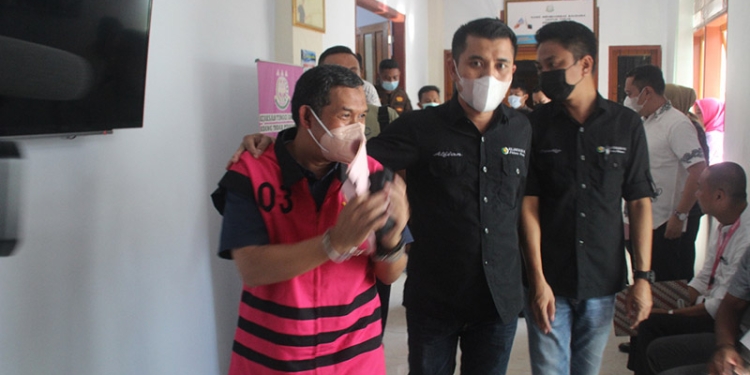 Kepala Dinas PUPR Pohuwato, AS, berjalan keluar dari ruang pemeriksaan Kejaksaan Tinggi Gorontalo, Jumat (17/6/2022). (istimewa)
