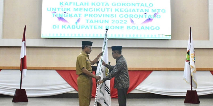 Sekretaris Daerah Kota Gorontalo, Ismail Madjid, menyerahkan bendera Kota Gorontalo kepada ketua rombongan kafilah Kota Gorontalo pada pemberangkatan kafilah Kota Gorontalo untuk MTQ tingkat Provinsi Gorontalo, Selasa (21/6/2022). (Pemkot Gorontalo)