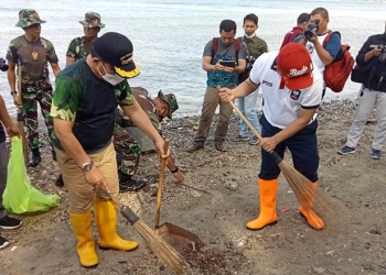 Wali Kota Gorontalo, Marten Taha bersama personil Korem 133, saat membersihkan tumpukan sampah di pesisir pantai blu Merlin, Jum'at (10/6/2022). Foto: Sari/gopos