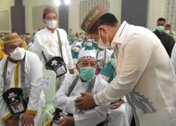 Penjagub Gorontalo, Hamka Hendra Noer, menyalami jemaah calon haji Provinsi Gorontalo Kloter 14 UPG saat berada di asrama haji Provinsi Gorontalo, Ahad (26/6/2022). (Haris/Pemprov Gorontalo)